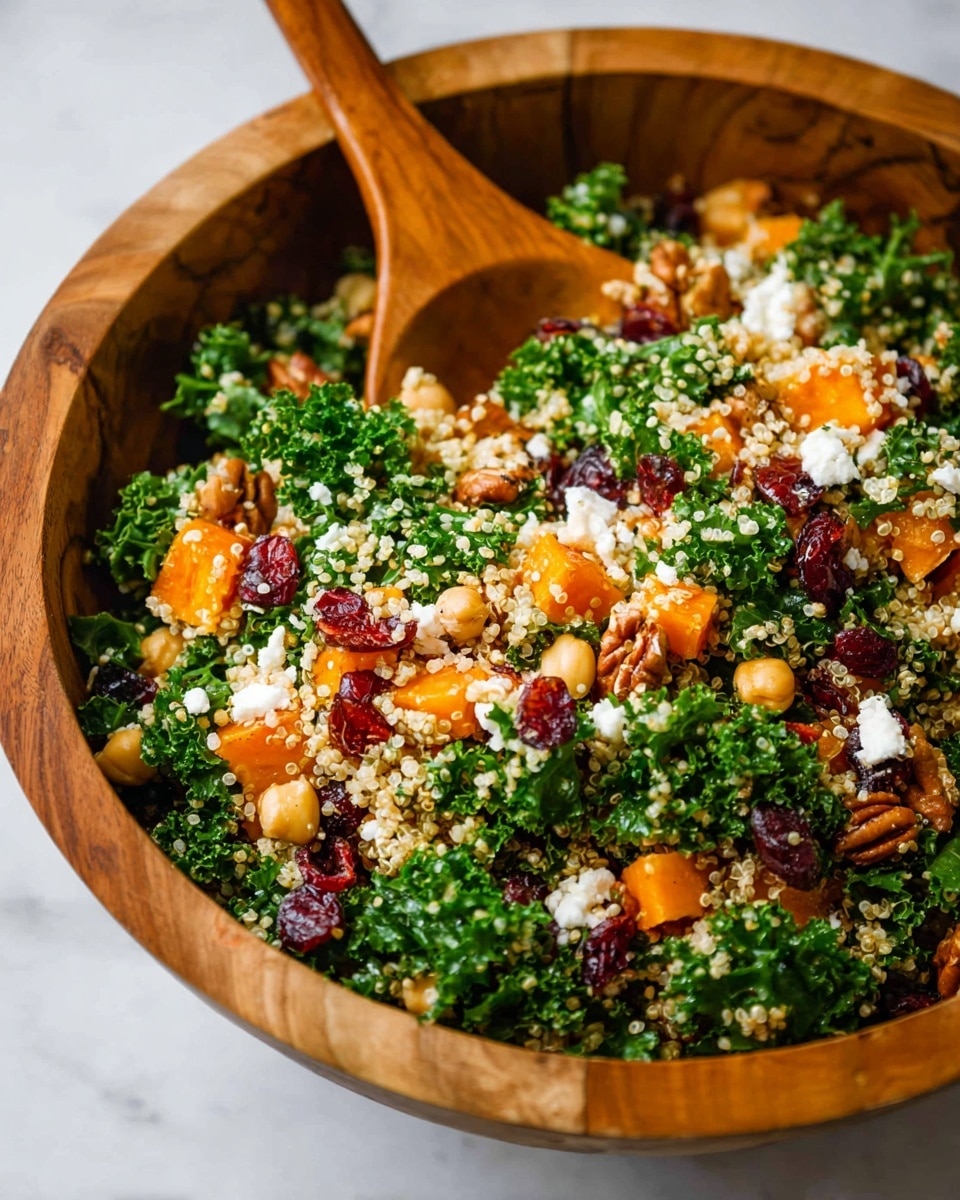 A wooden bowl filled with a colorful salad on a white marbled surface shows three main layers: the base is bright green kale leaves with a textured, curly appearance; scattered on top are small, round, pale yellow quinoa grains that add a light, fluffy texture; mixed throughout are chunks of golden orange roasted sweet potatoes, deep red dried cranberries, and brown pecan pieces, adding varied textures and vibrant pops of color. photo taken with an iphone --ar 4:5 --v 7