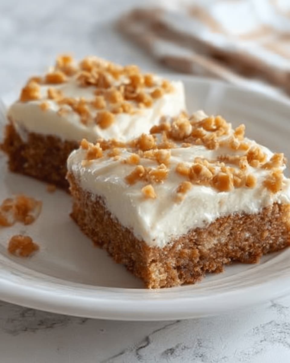 Two square pieces of cake sit on a white plate with a white marbled background. Each piece has two visible layers: a thick, moist brown base layer with a soft, crumbly texture, and a thick top layer of creamy white frosting evenly spread. The frosting is decorated with a generous amount of small caramel-colored bits scattered on top. The photo taken with an iphone --ar 4:5 --v 7