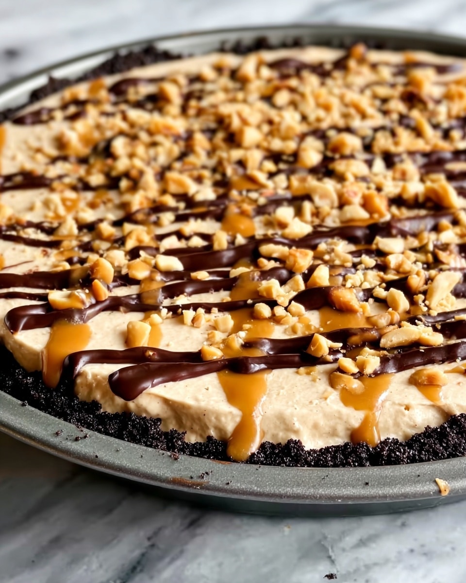 A close-up of a dessert with three main layers: the bottom layer is a dark, crumbly chocolate crust forming the base; the middle layer is a smooth, creamy light brown filling spread evenly over the crust; the top layer is decorated with chopped light brown nuts scattered all over, with thin, uneven drizzles of dark chocolate sauce and a slightly lighter caramel sauce adding contrast and shine across the surface. The dessert is in a metal pan resting on a white marbled texture. Photo taken with an iphone --ar 4:5 --v 7