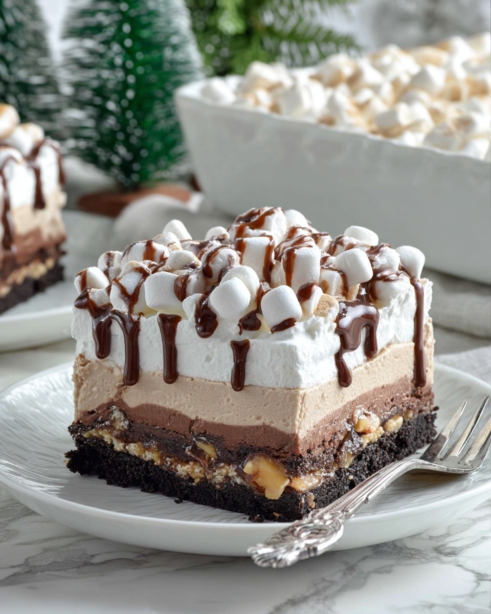 A square slice of a layered dessert sits on a white plate over a white marbled surface. The bottom layer is a dark, crumbly cookie crust. Above this is a light brown creamy layer with a smooth texture. The next layer is a thick, darker chocolate layer that looks rich and dense with bits of nuts inside. The top layer is fluffy white whipped cream covered with many small white marshmallows. Drizzled over the marshmallows is a light brown chocolate sauce creating thin, wavy lines. A shiny silver fork lies on the right side of the plate. The background features a small green tree decoration and part of a clear glass container holding more of the dessert. Photo taken with an iphone --ar 4:5 --v 7