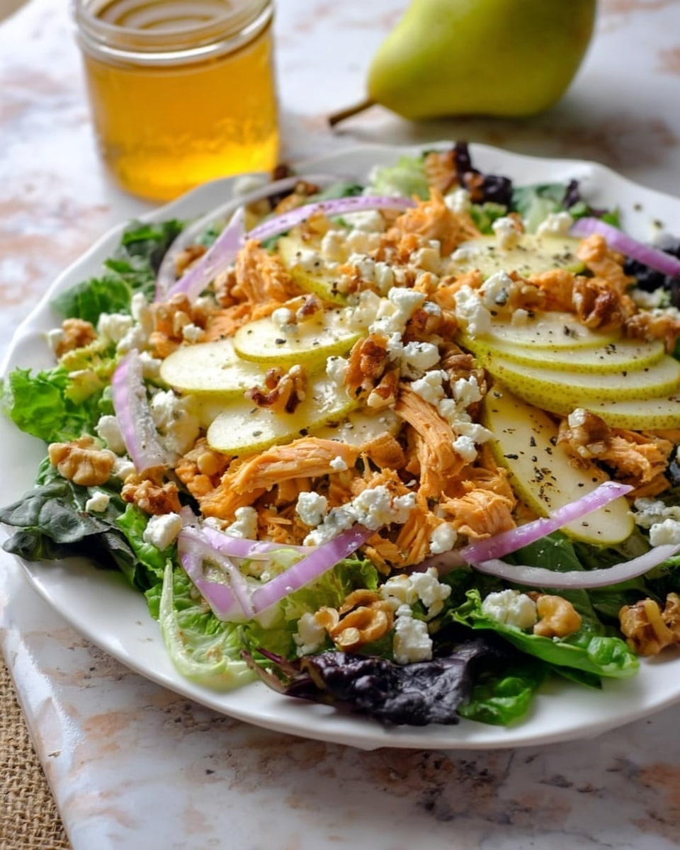 A white plate holds a fresh salad with several layers, starting with a bed of dark green leafy lettuce at the bottom, topped with shredded orange chicken pieces. On top of this are slices of light green pear arranged in a scattered pattern. Crumbled white cheese is spread over the pears, mixed with small pieces of chopped walnuts that add a rough texture. Thin slices of purple onion are sprinkled across the salad, providing a pop of color. The salad appears lightly seasoned with black pepper. In the background, a small glass jar filled with golden honey sits on a white marbled surface next to a green pear. Photo taken with an iphone --ar 4:5 --v 7