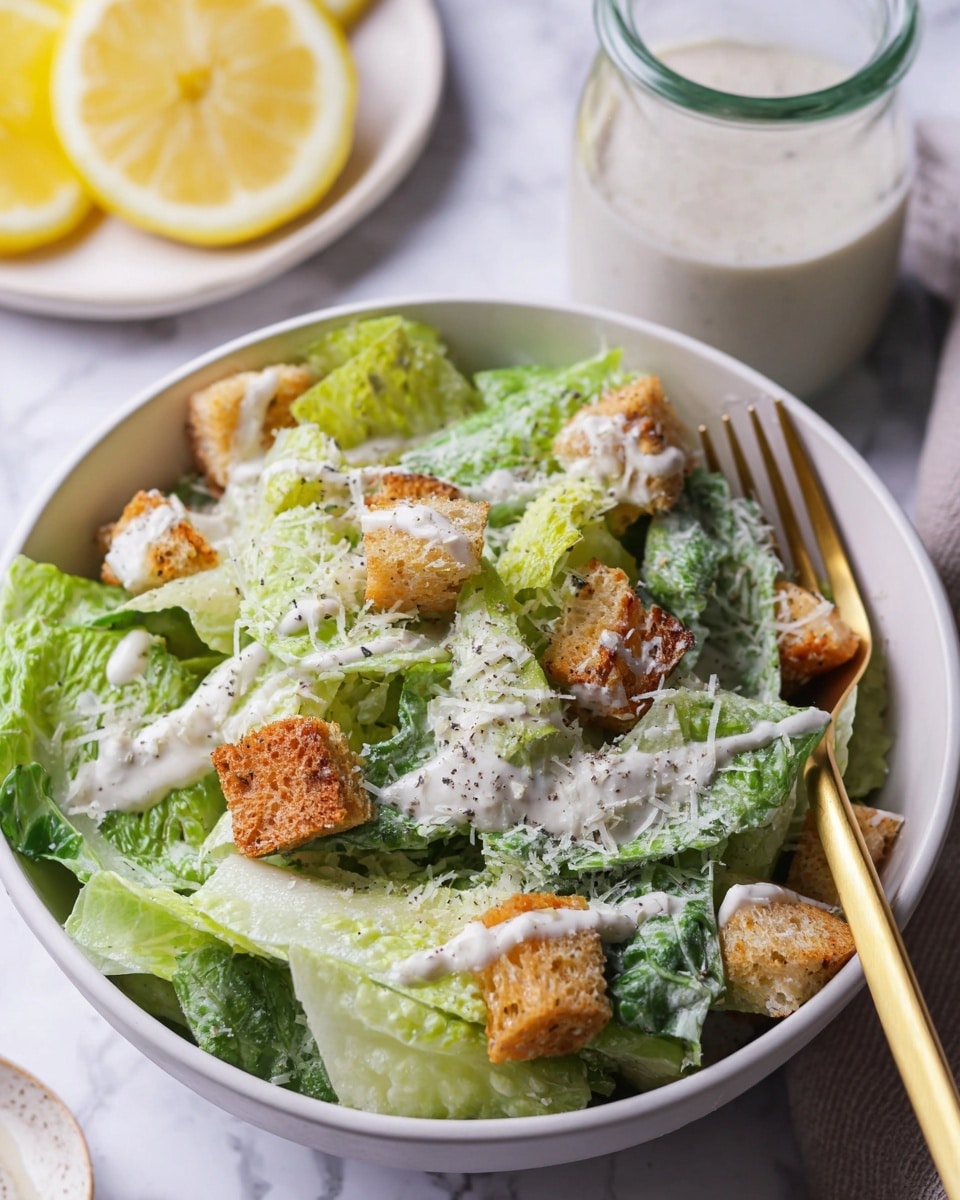 A glass jar filled with creamy, pale yellow sauce speckled lightly with black pepper sits on a small round wooden board placed on a white marbled surface. A golden spoon sticks out of the jar, and the jar's lid is open and leaning to the right. Around the jar, there are scattered pieces of garlic cloves, a wedge of lemon, some fresh green lettuce leaves, and a block of cheese. In the background, a tall wooden pepper grinder stands against a blurred white marbled wall. The whole setting looks fresh and bright with natural light. photo taken with an iphone --ar 4:5 --v 7